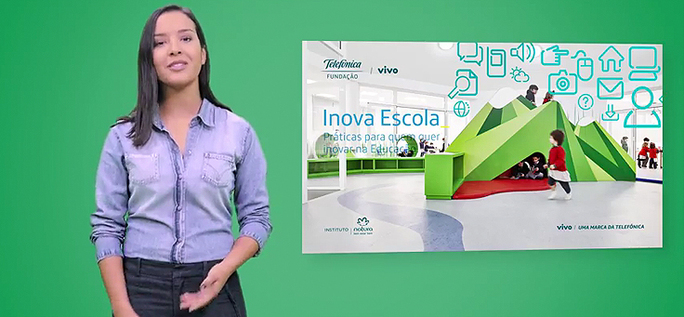 Apresentadora mostra livro Inova Escola, em fundo verde.