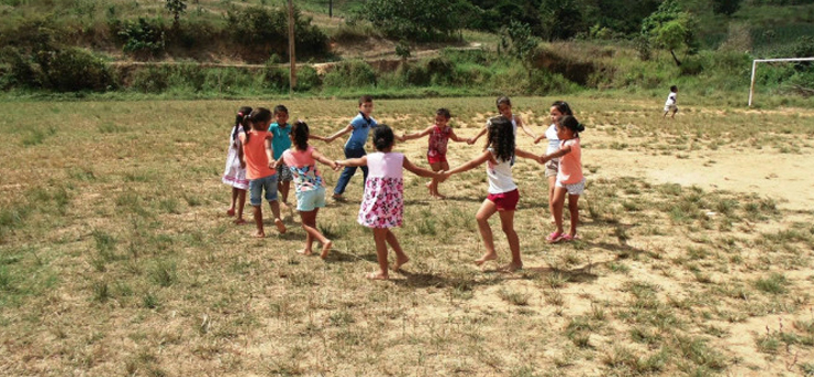 Ciranda de crianças em um gramado, ao ar livre (ECA e Legislação, Sistema de Garantia dos Direitos da Criança e do Adolescente)