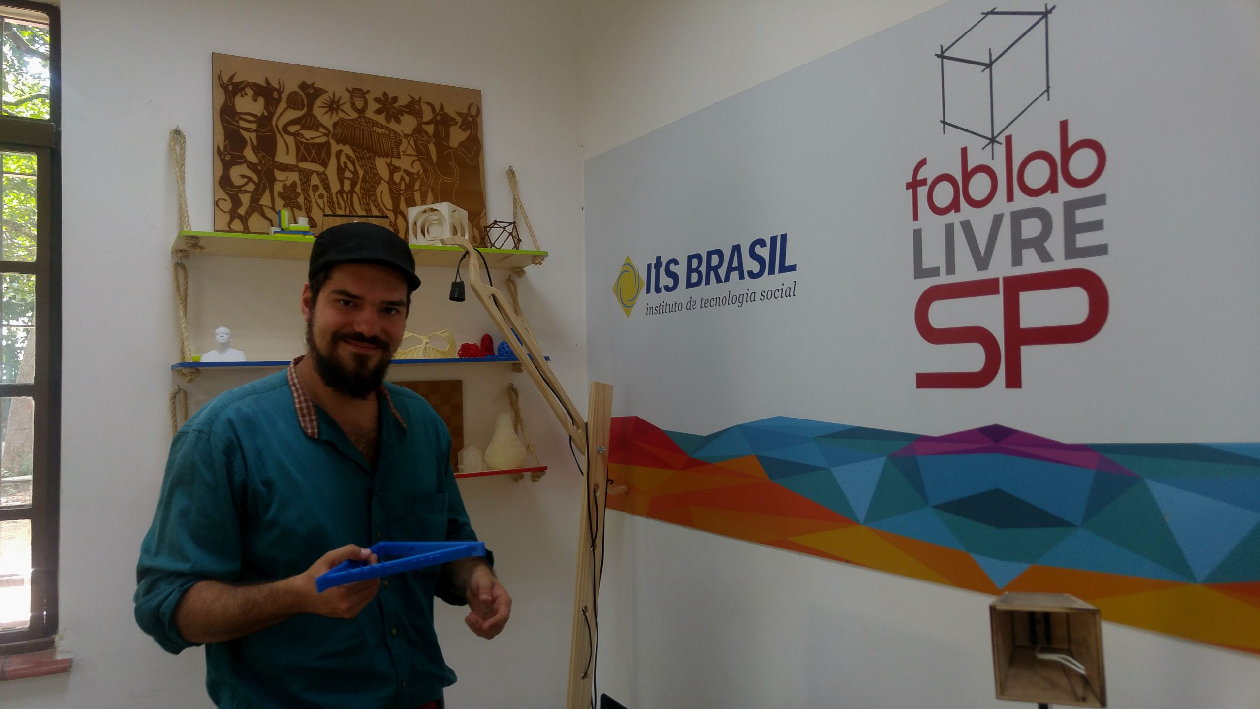 Imagem mostra Lucas Schlosinski usando uma boina. Ao fundo se lê Fab Lab SP