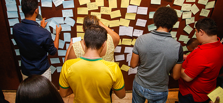 Imagem mostra jovens em frente a um mural