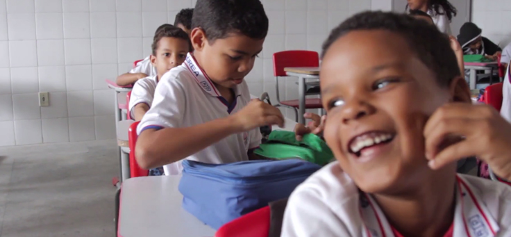 Imagem mostra frame do vídeo do projeto Aula Digital em Sergipe com crianças sorrindo em sala de aula