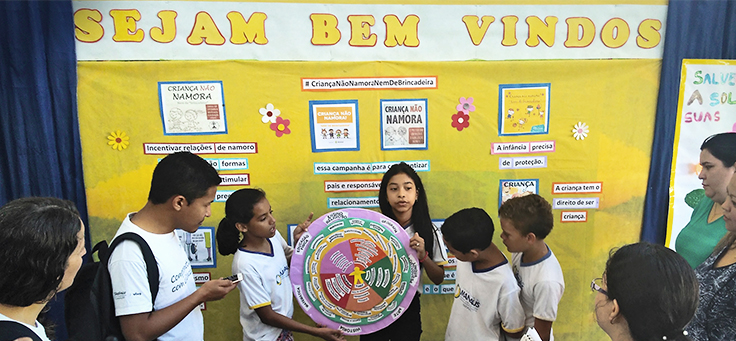 Seis crianças apresentam cartaz em forma de mandala