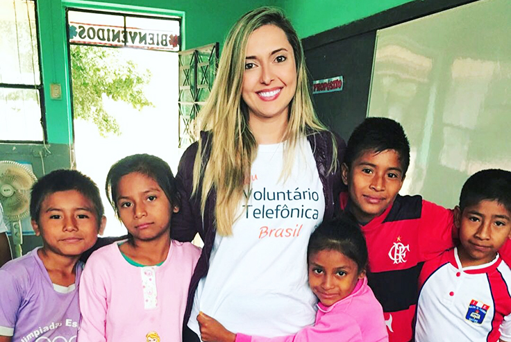 Camila Silva ao lado de crianças peruanas em escola