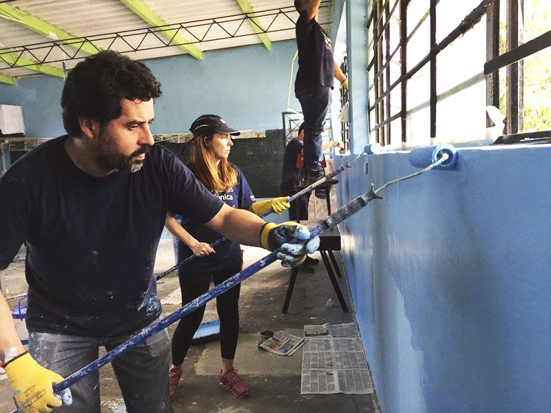 Voluntários pintam parede da escola Molino de Carmen, no Peru