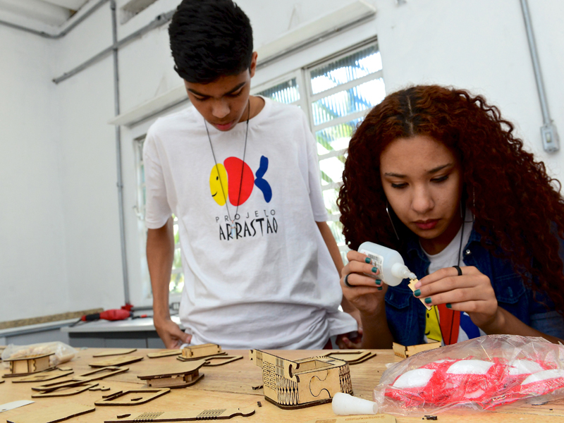 Jovens trabalham em mesa de moldes no Lab Maker Arrastão