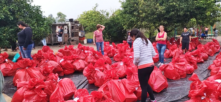 Dezenas de Sacolas com doações de voluntários da fundação telefônica vivo no chão para triagem