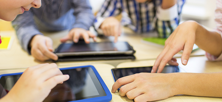 Imagem mostra grupo de quatro pessoas usando tablets