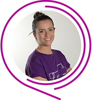 Maria Tereza, do Programa de Voluntariado da Fundação Telefônica Vivo, usa camiseta púrpura, tem o cabelo enrolado em um coque e sorri