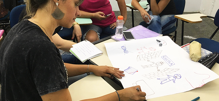 Professora está desenhando em cartolina durante dinâmica de formação continuada da Fundação Telefônica Vivo em parceria com a Undime.