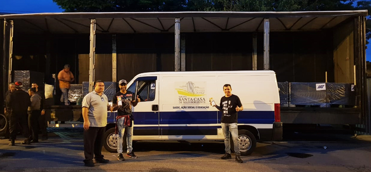 Tiago Elvis está posando em frente a van que transporta leites para Santa Casa de Belo Horizonte. O voluntário atua em diversas causas sociais.