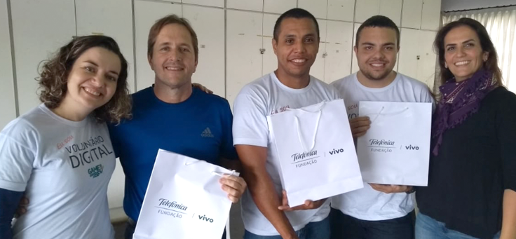 Na imagem, os vencedores do Game do Bem e colaboradores do Grupo Telefônica posam para foto com sacolas de brindes