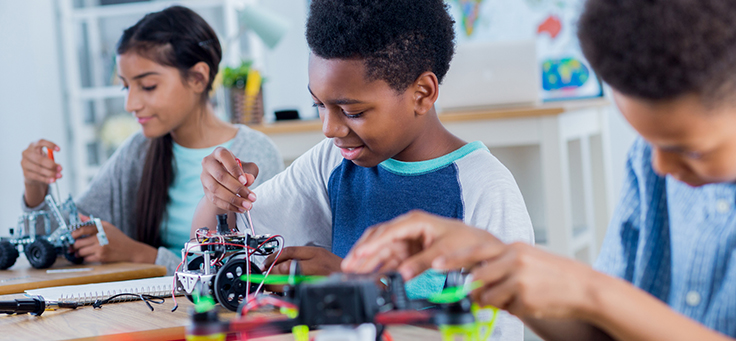 Imagem mostra três estudantes fazendo atividades maker