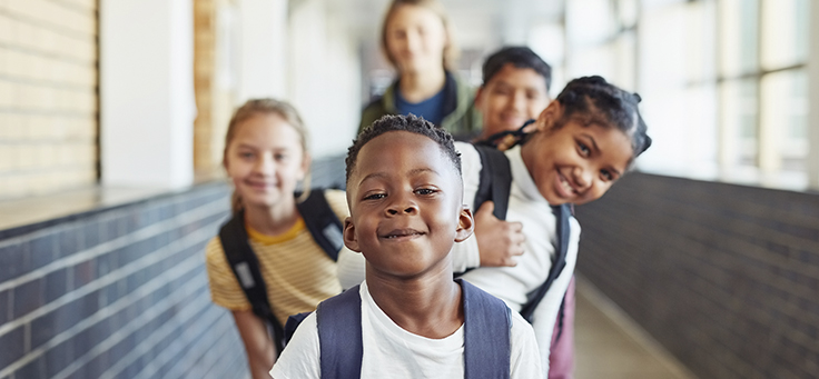 Imagem mostra crianças sorrindo em uma fila