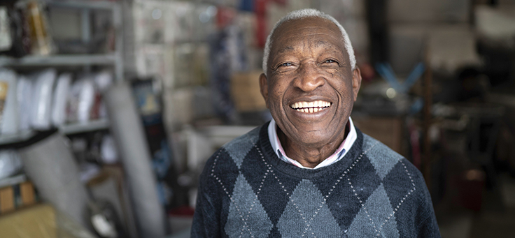 A imagem mostra um homem idoso sorrindo