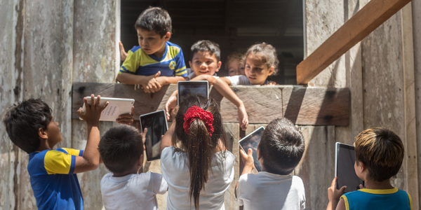 Crianças em Manaus que fazem do projeto Aula Digital ProFuturo seguram tablets do projeto