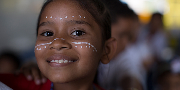 Criança de escola em Manaus atendida pelo Aula Digital PRoFuturo sorri para a foto. Ela tem o rosto pintado com tinta branca.