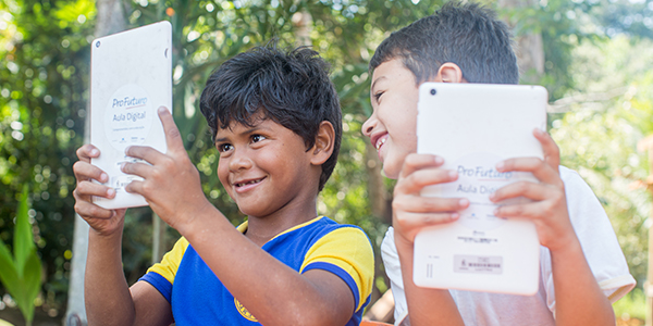 Crianças em Manaus que fazem do projeto Aula Digital ProFuturo seguram tablets do projeto