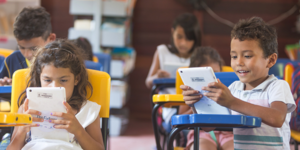 Crianças em Manaus que fazem do projeto Aula Digital ProFuturo seguram tablets do projeto em uma sala de aula