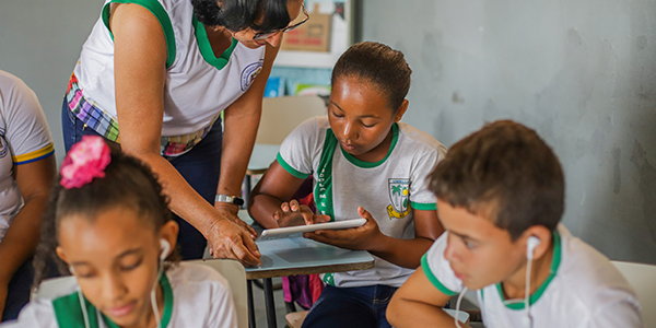 Professora ensina aluna a mexer no tablet do projeto Aula Digital em uma escola de Sergipe