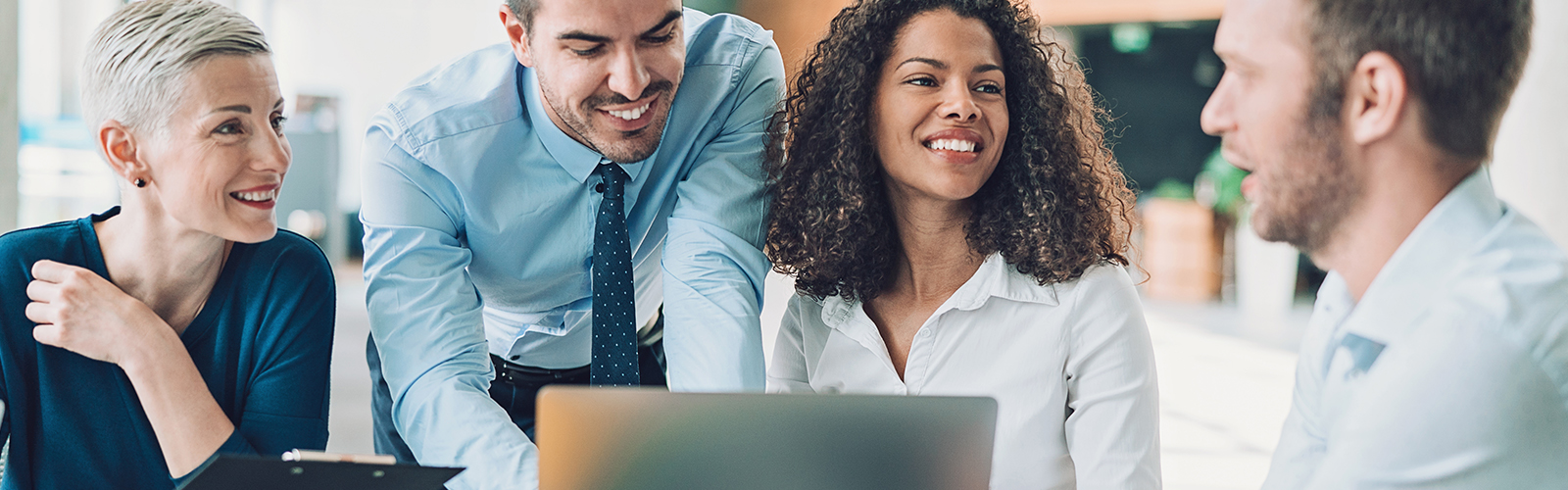 grupo de colabadores de uma empresa sorriem durante uma reunião