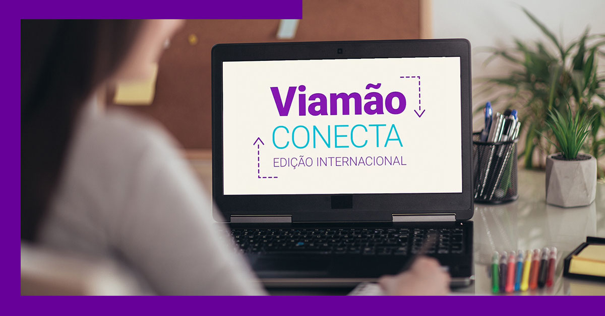 Imagem mostra uma mulher utilizando um notebook. O aparelho está ligado e na tela é possível ver a apresentação do evento Viamão Conecta – Edição Internacional