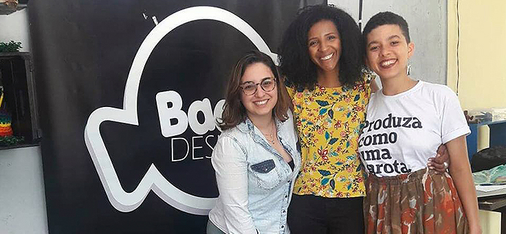 Idealizadora do Badu Design, Ariane Santos, posa para foto ao lado de mulheres.