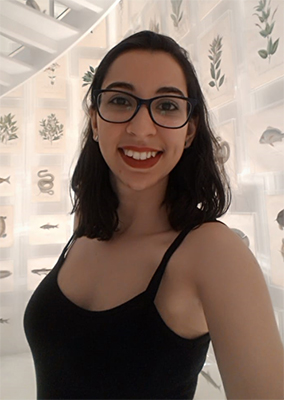 Aline Omar, do projeto TecLar e Embaixadora de Oportunidades da Rede Pense Grande, está usando óculos, blusa preta de alça e sorri para a foto.