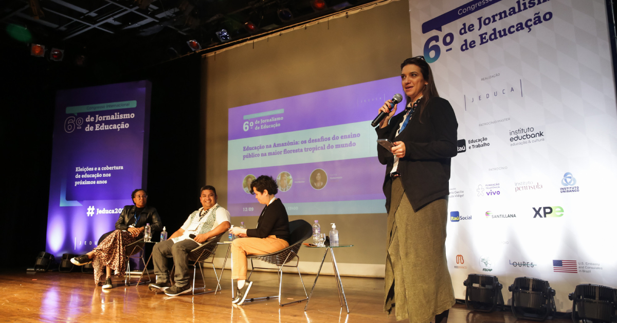 Mesa de debate com convidados, mediadora e apresentadora durante o Congresso Internacional de Jornalismo de Educação da Jeduca.