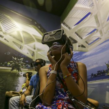 Criança negra utiliza óculos de realidade virtual durante visita ao Museu do Amanhã, no Rio de Janeiro (RJ)