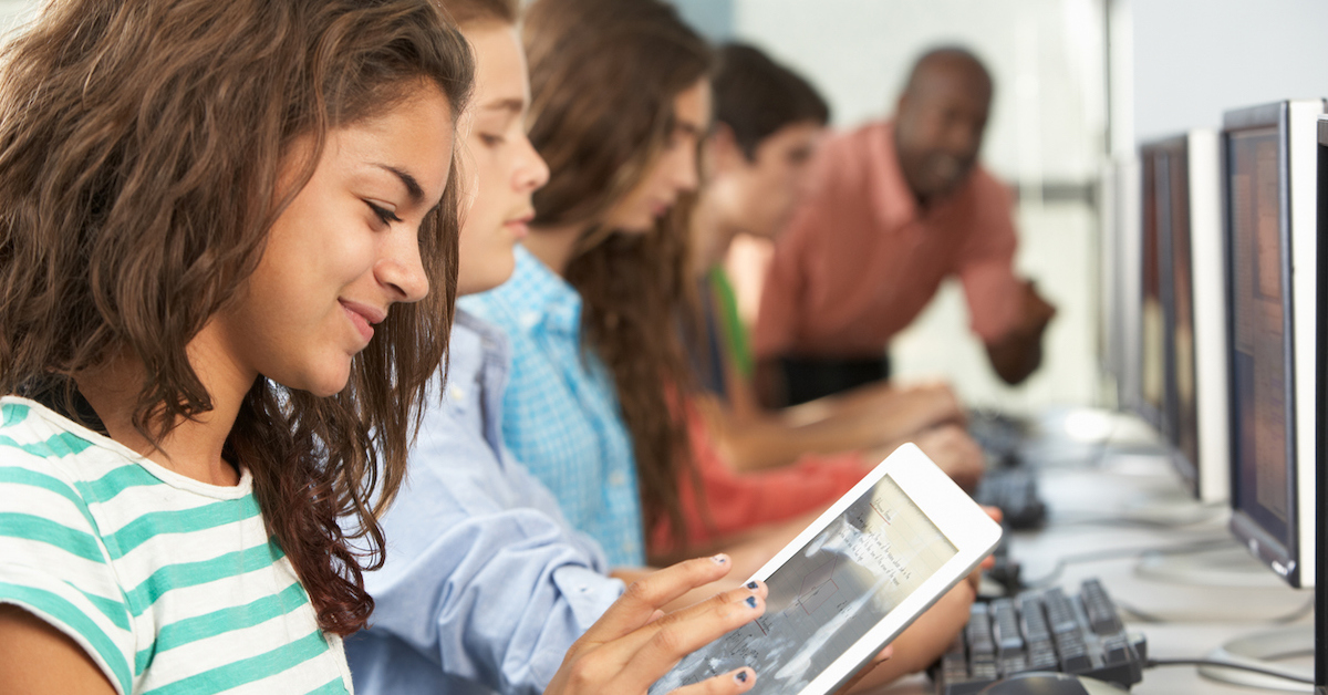 Aluna utiliza tablet durante aula na sala de informática da escola.