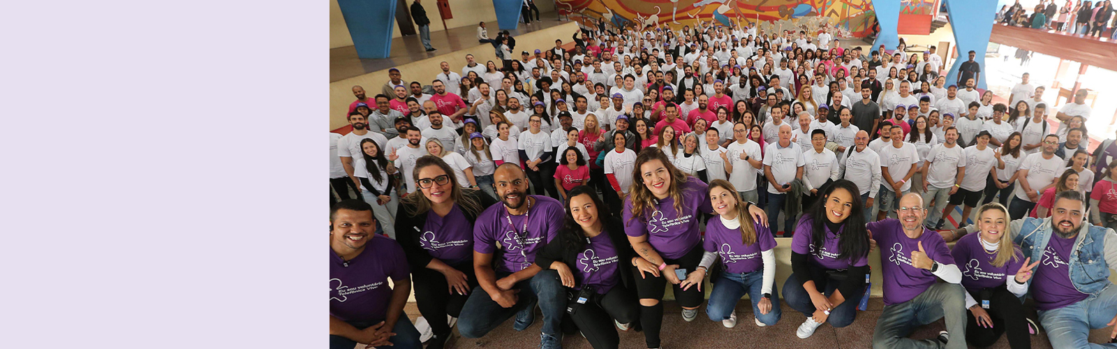 Imagem mostra um grupo de mais de 100 pessoas reunidas que atuaram como voluntárias no dia dos voluntários