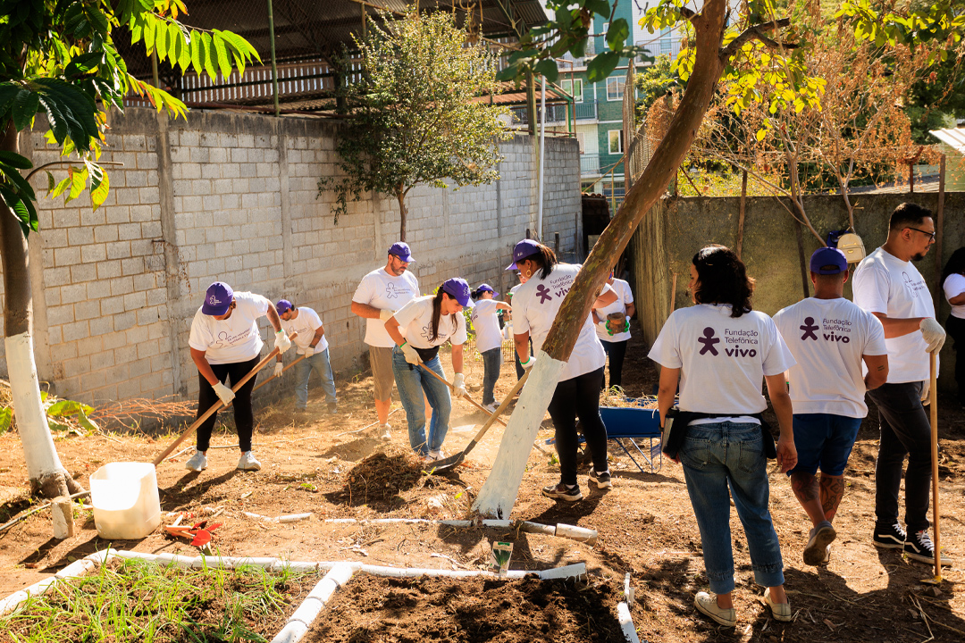 Na imagem vemos grupo de voluntários trabalhado em uma horta