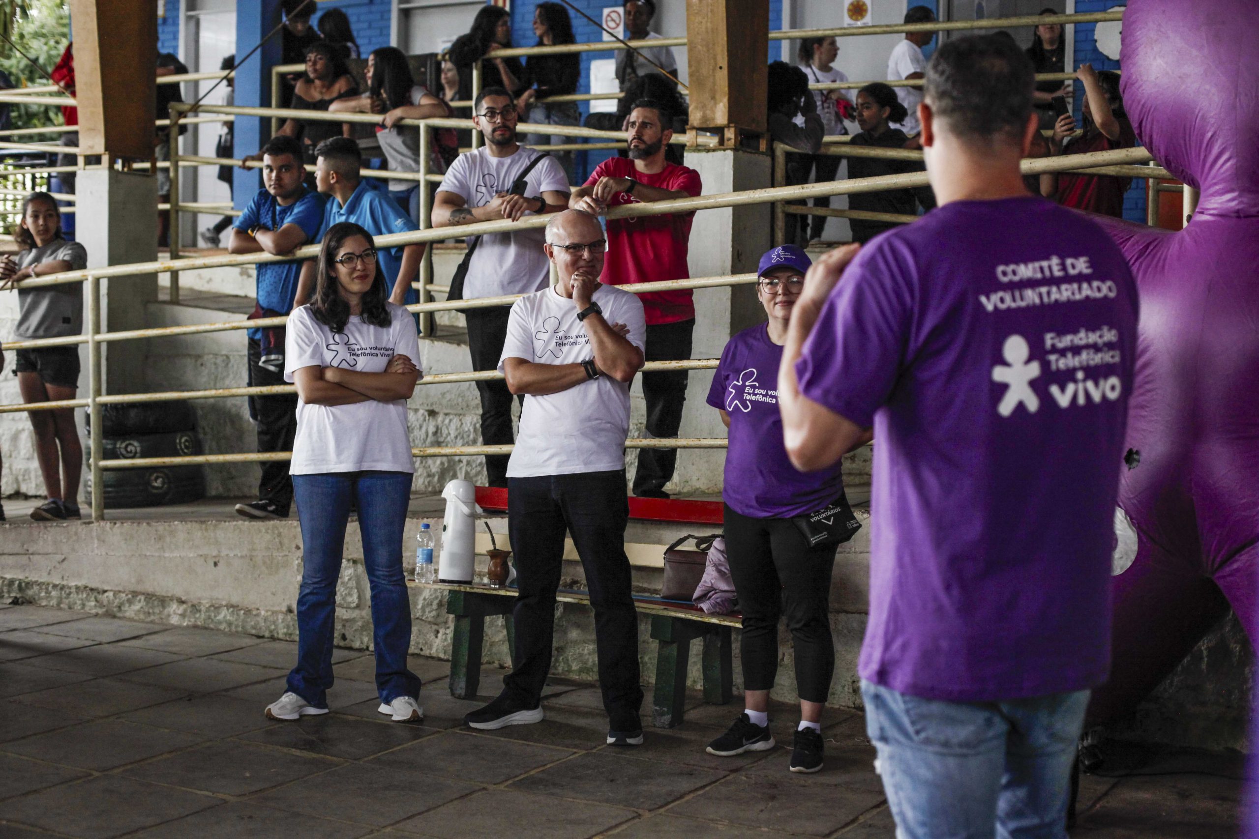 Voluntários ouvem homem com uma camiseta escrita 