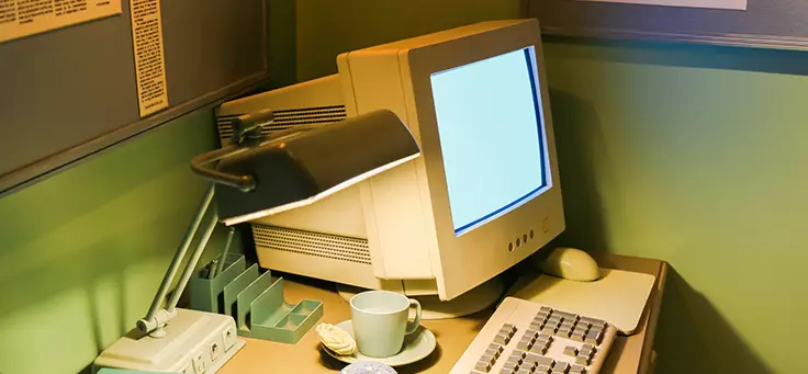 Para falar sobre os 50 anos da internet, imagem mostra monitor, CPU e teclado de computador antigo sobre uma mesa de trabalho.