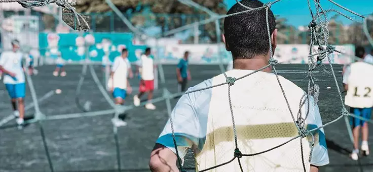 Projetos sociais esportivos: imagem mostra meninos de uniforme em um campo de futebol