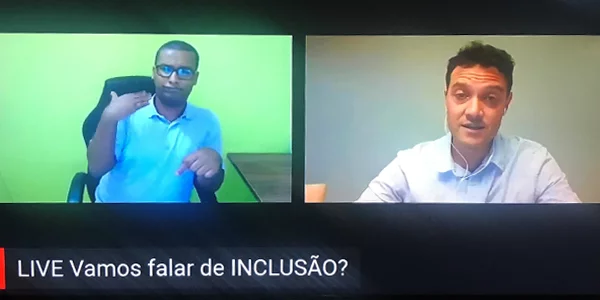 Educador Igor Zucchi está falando em live da Associação Cararinense para a Integração do Cego durante a Semana dos Voluntários. Ele divide a tela com um intérprete de Libras.