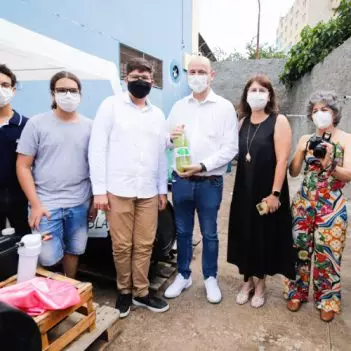 Alunos e professores posam para foto com biogás em uma garrafa pet, resultado do projeto de ciências Tesla.