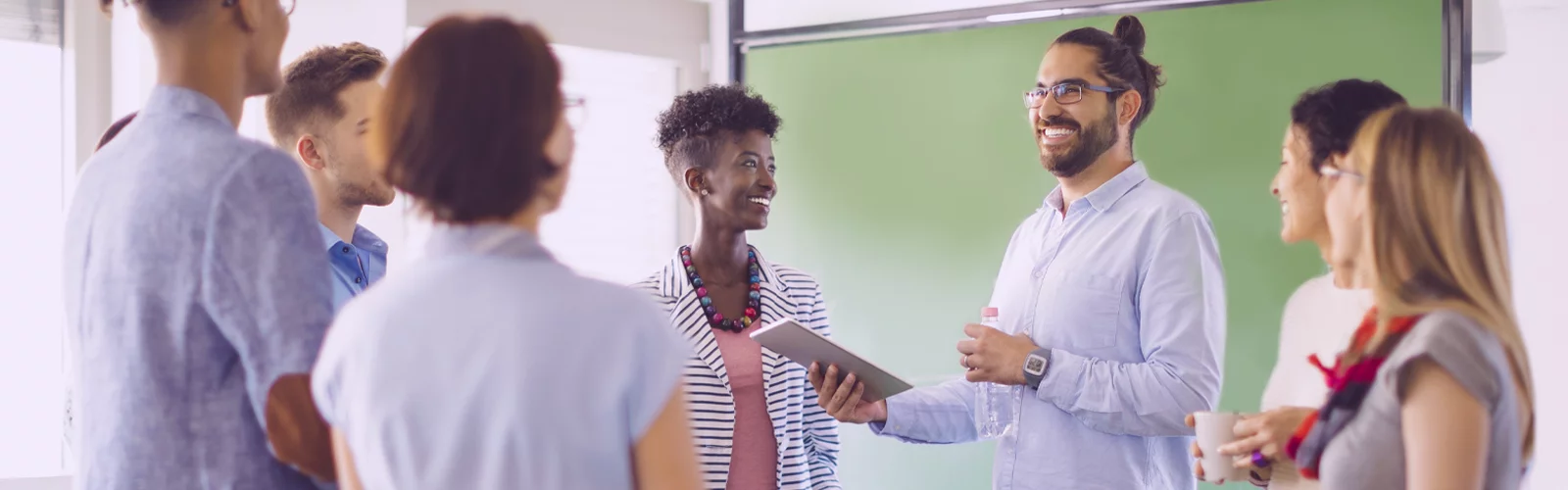 Imagem mostra um grupo de pessoas reunidas. Há homens e mulheres, brancos e negros. Parecem estar conversando.